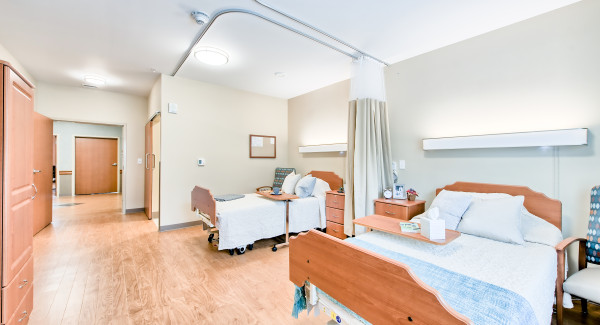 Private and semi-private room with bed and chairs
